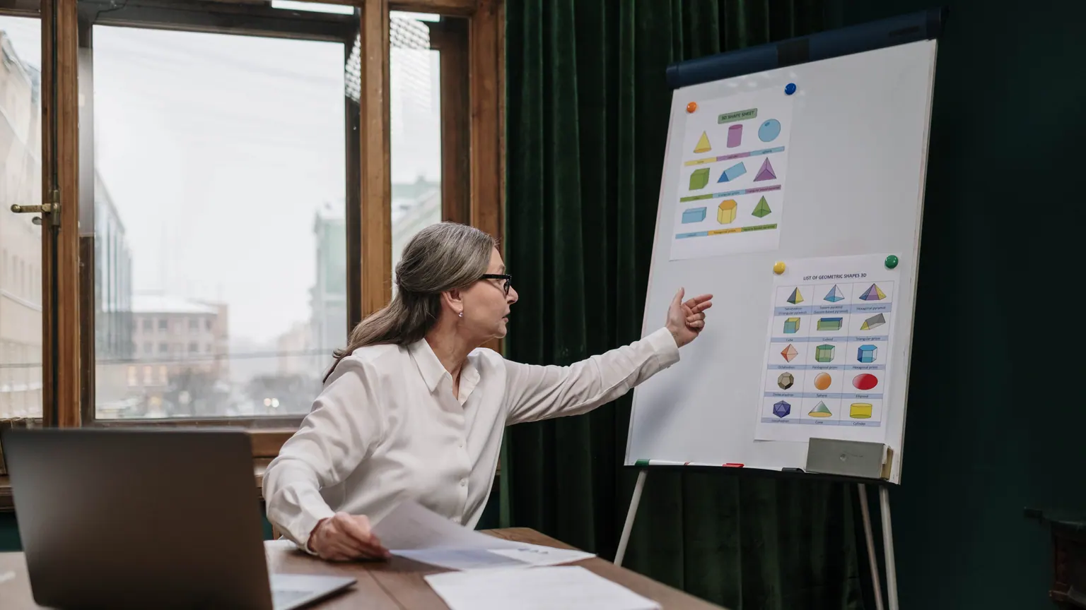 Professora aponta relações visuais em um quadro durante uma explicação